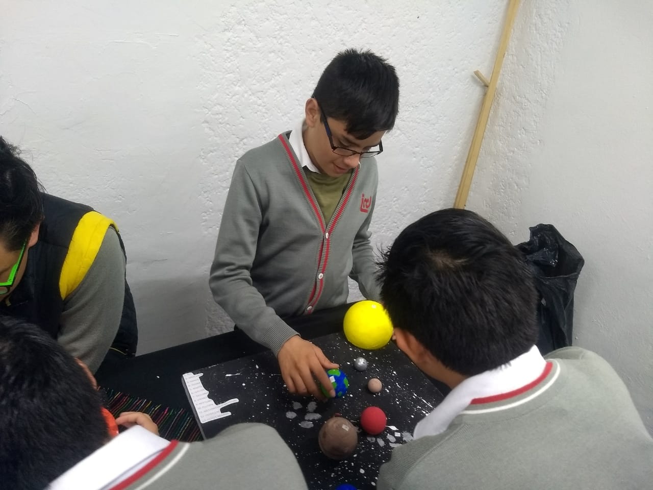 Un alumno de secundaria acomoda los planetas de una maqueta del sistema solar